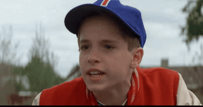 A Young Boy Wearing A Blue Baseball Cap With The Letter T On It GIF