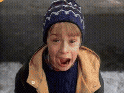 A Young Boy Wearing A Blue Hat And A Yellow Jacket GIF