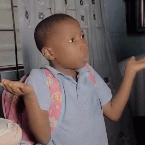A Young Boy Wearing A Blue Shirt And A Pink Backpack Is Shrugging His Shoulders GIF