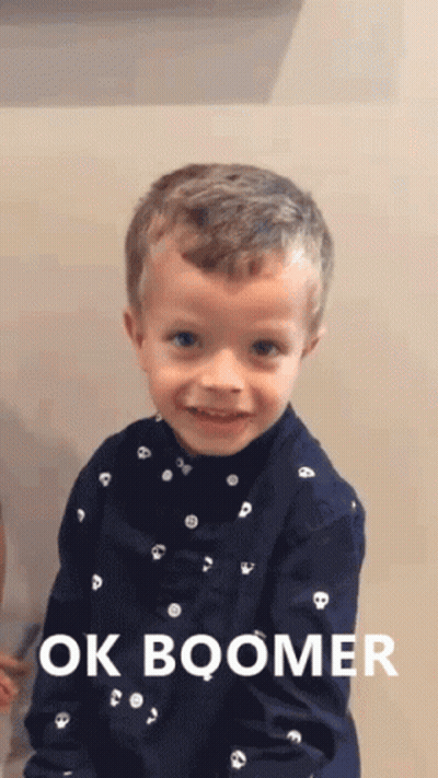 A Young Boy Wearing A Blue Shirt That Says Ok Boomer On It GIF