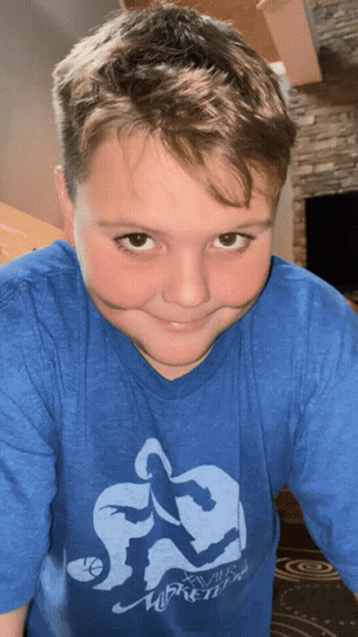 A Young Boy Wearing A Blue Shirt That Says Xvii Basketball GIF