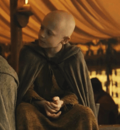 A Young Boy Wearing A Cape Is Sitting In A Tent GIF