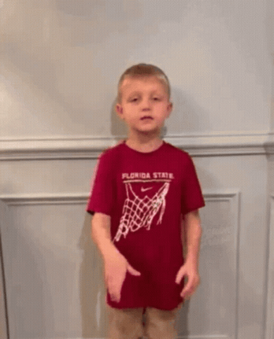 A Young Boy Wearing A Crown And A Shirt That Says Go Noles GIF