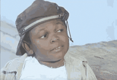 A Young Boy Wearing A Hat And A Jacket Is Making A Face . GIF