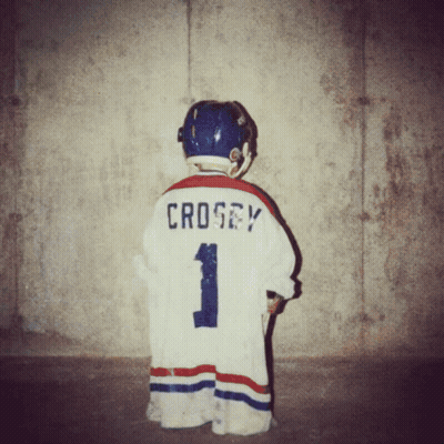 A Young Boy Wearing A Hockey Jersey With The Name Crosby On The Back GIF