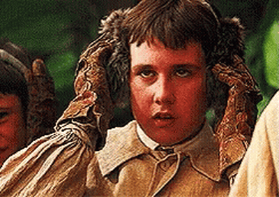 A Young Boy Wearing A Pair Of Gloves Covering His Ears GIF