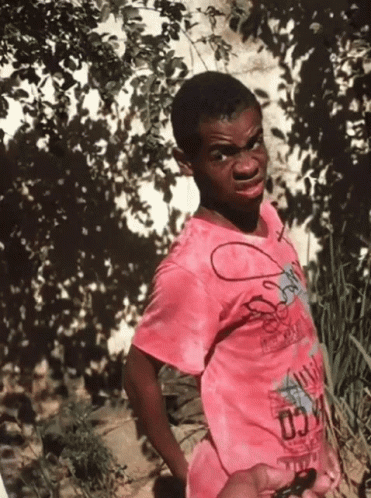 A Young Boy Wearing A Pink Shirt That Says Chicago GIF