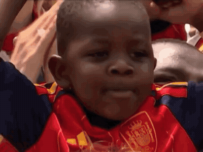 A Young Boy Wearing A Red And Blue Jersey With A Shield On It GIF