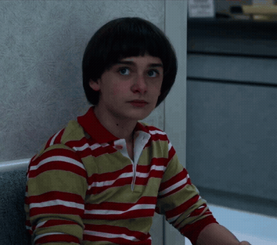 A Young Boy Wearing A Red And White Striped Shirt Looks At The Camera GIF