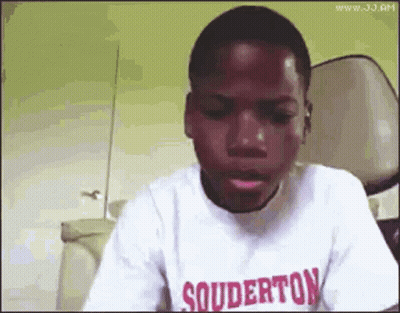 A Young Boy Wearing A Souderton T-Shirt Is Making A Funny Face . GIF