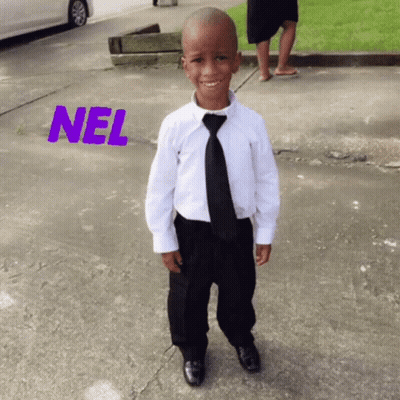 A Young Boy Wearing A White Shirt And Black Tie Is Standing On A Sidewalk With The Word Nel Above Him GIF