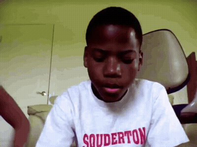 a young boy wearing a white shirt that says souderton