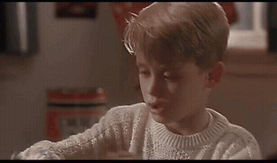 A Young Boy Wearing A White Sweater Is Looking At A Book GIF