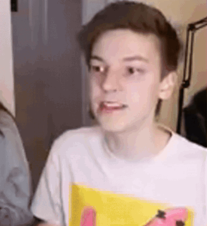 A Young Boy Wearing A White T-Shirt With A Yellow Spongebob Print Is Making A Face . GIF