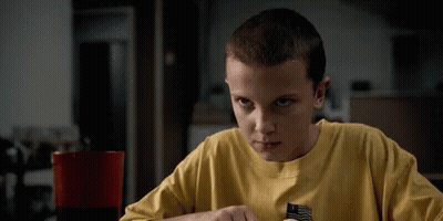 A Young Boy Wearing A Yellow Shirt Is Sitting At A Table . GIF