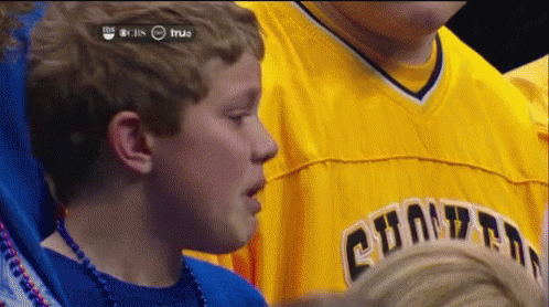 A Young Boy Wearing A Yellow Shirt That Says Champions On It GIF