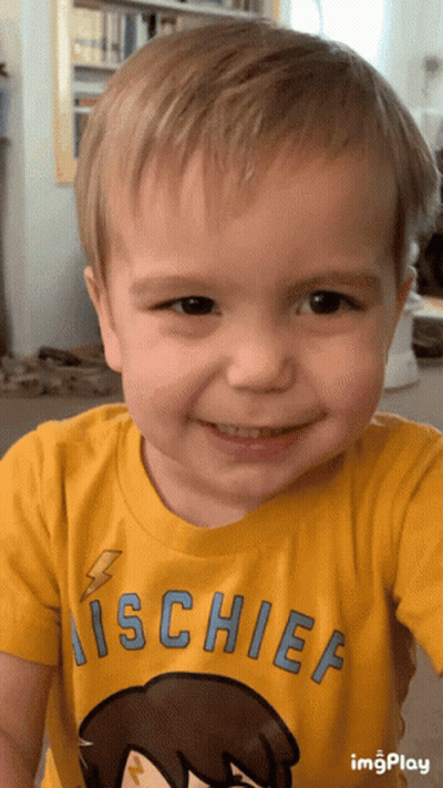 A Young Boy Wearing A Yellow Shirt That Says ' Mischief ' On It GIF