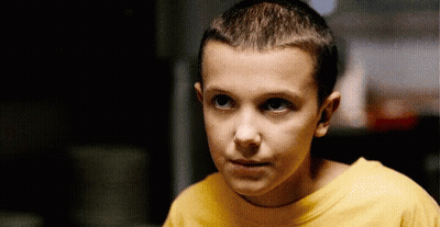 A Young Boy Wearing A Yellow T-Shirt Is Looking At The Camera . GIF