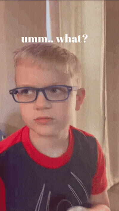 A Young Boy Wearing Glasses And A Spiderman Shirt Is Making A Funny Face And Asking What . GIF