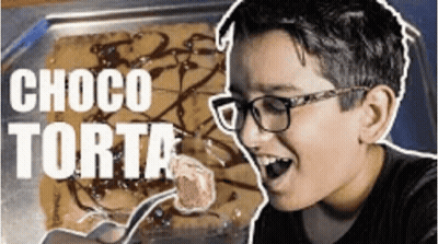 A Young Boy Wearing Glasses Is Eating A Chocolate Cake . GIF