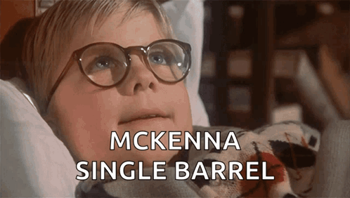 A Young Boy Wearing Glasses Is Laying In A Bed With The Words Mckenna Single Barrel Below Him GIF