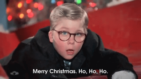 A Young Boy Wearing Glasses Is Laying On The Ground And Saying Merry Christmas . Ho , Ho , Ho . GIF