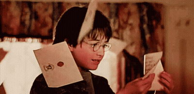 A Young Boy Wearing Glasses Is Reading A Letter GIF