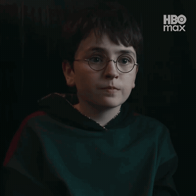 A Young Boy Wearing Glasses Is Smiling In A Dark Room With Hbo Max Written On The Bottom GIF