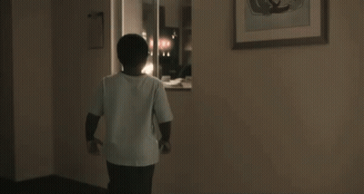 A Young Boy Wearing Glasses Is Standing In A Doorway With His Mouth Open And A Surprised Look On His Face . GIF