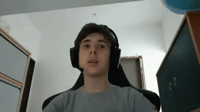 A Young Boy Wearing Headphones Is Sitting In A Chair In A Room . GIF