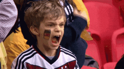 A Young Boy With A German Flag Painted On His Face Is Screaming GIF