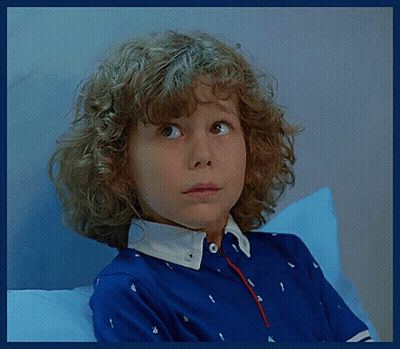A Young Boy With Curly Hair Wearing A Blue Shirt GIF