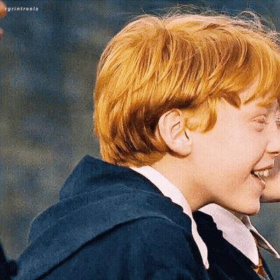 A Young Boy With Red Hair Is Smiling While Wearing A Blue Hoodie . GIF