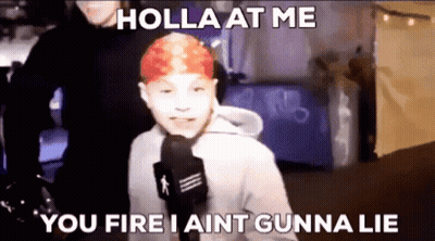 A Young Boy With Red Hair Is Talking Into A Microphone . GIF
