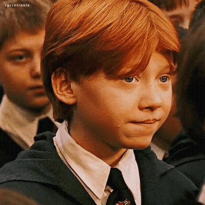 A Young Boy With Red Hair Is Wearing A Suit And Tie And Making A Face . GIF