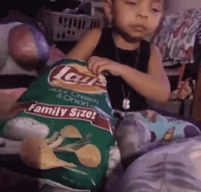 A Young Child Is Holding A Bag Of Lays Chips GIF