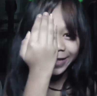 A Young Girl Is Covering Her Eyes With Her Hand . GIF