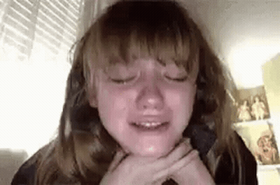 A Young Girl Is Crying While Sitting In A Chair With Her Eyes Closed . GIF
