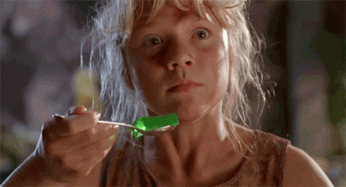 A Young Girl Is Eating Jelly With A Spoon GIF