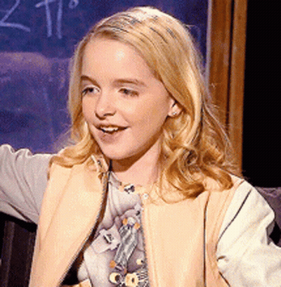 A Young Girl Is Smiling In Front Of A Blackboard With The Number 2 On It GIF
