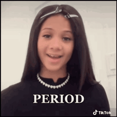 A Young Girl Wearing A Black Shirt And A Necklace Is Smiling . GIF