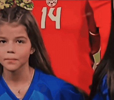 A Young Girl Wearing A Blue Shirt With The Number 14 On It GIF