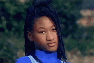 A Young Girl With Dreadlocks Is Wearing A Blue Turtleneck And Overalls GIF