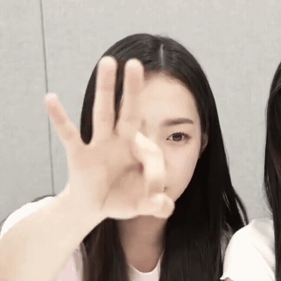 A Young Girl With Long Black Hair Is Making A Stop Sign With Her Hand . GIF