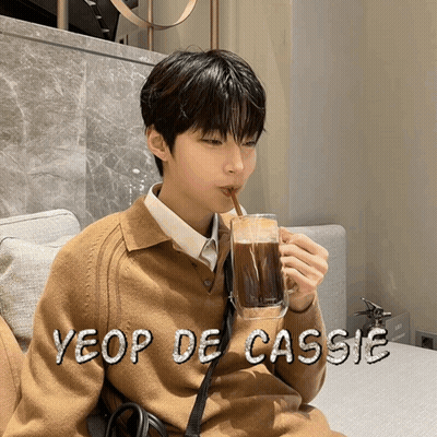 A Young Man Drinking A Cup Of Coffee With The Name Yeop De Cassie Written On The Bottom GIF