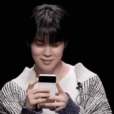 A Young Man Holding A Cell Phone In His Hands GIF
