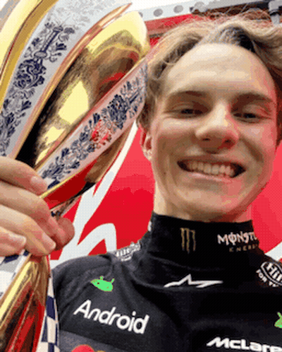A Young Man Holding A Trophy That Says Android On His Shirt GIF