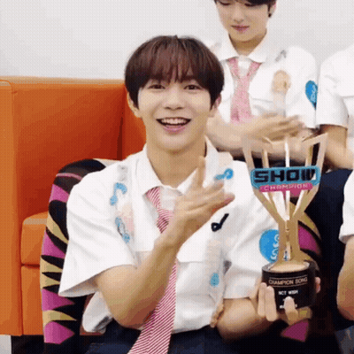 A Young Man Holding A Trophy That Says Show Champion On It GIF