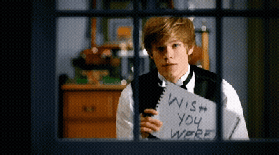 A Young Man Holds A Notebook That Says Wish You Were GIF