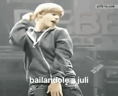 A Young Man In A Black Hoodie Is Dancing On A Stage In Front Of A Crowd . GIF